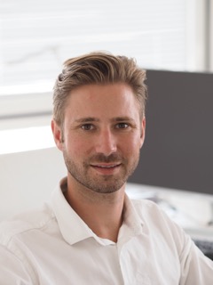 Hausmeisterservice Bauer Team - Junger Mann mit blonden kurzen Haaren und weißem Hemd lächelt