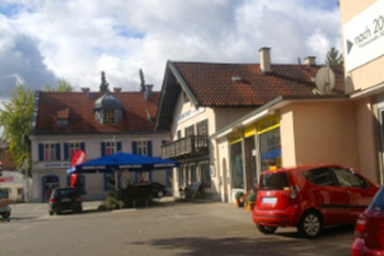 Hausmeisterservice Bauer Referenzen München - Blauer Sonnenschirm und rotes Auto vor Häusern in München